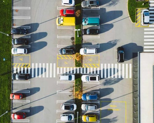 Vertical photo directly above a parking lot, colorful cars parked on it